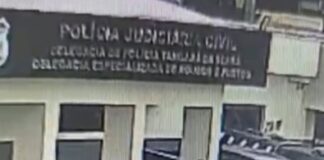 mulher-picha-carro-de-policial-com-simbolo-do-cv-na-frente-de-delegacia